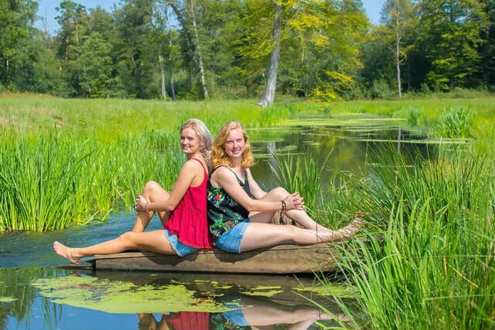 Framed Print : Two young dutch women sit at water in nature Framed Print : Two young dutch women sit at water in nature