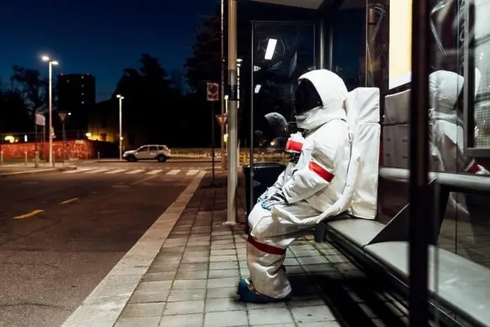 Framed Print : Young female astronaut in space suit waiting at bus stop during night