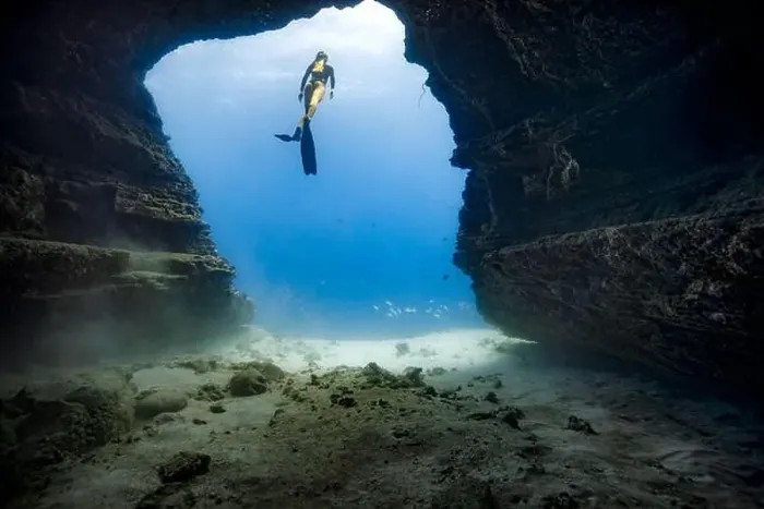 Framed Print : A young female free diving down into a cave doorway in the clear blue waters of Hawaii framed by shadowy cave walls Framed Print : A young female free diving down into a cave doorway in the clear blue waters of Hawaii framed by shadowy cave walls