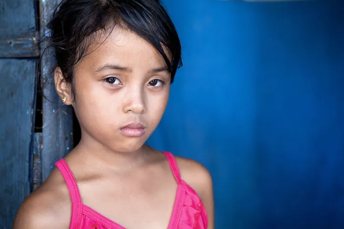 Framed Print : Young Filipina girl 8 years old with sad and somber expression over blue, poverty in the Philippines Framed Print : Young Filipina girl 8 years old with sad and somber expression over blue, poverty in the Philippines
