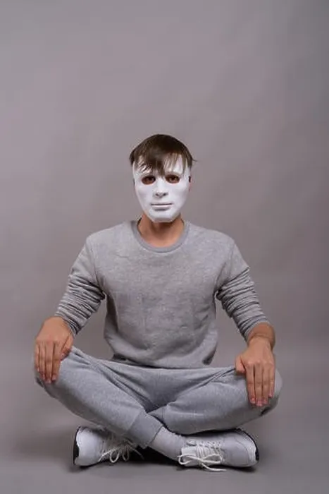 Framed Print : Young handsome man wearing white mask against gray background Framed Print : Young handsome man wearing white mask against gray background