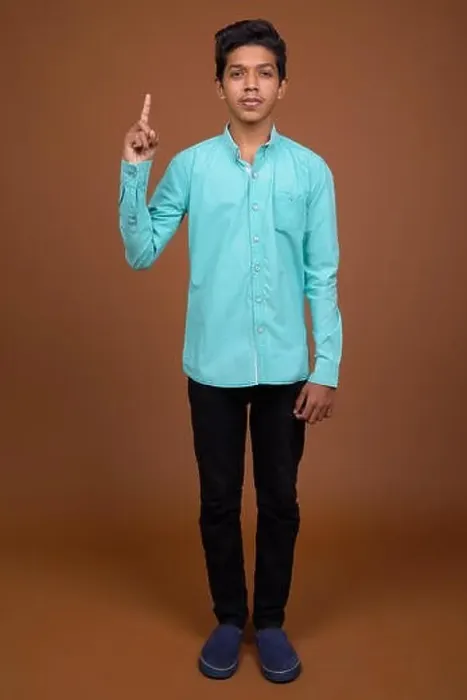 Framed Print : Young Indian boy wearing blue shirt looking smart against brown Framed Print : Young Indian boy wearing blue shirt looking smart against brown
