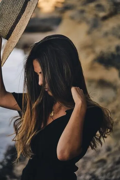 Framed Print : Young long haired smiling female model looking away holding hat in air on beach Framed Print : Young long haired smiling female model looking away holding hat in air on beach