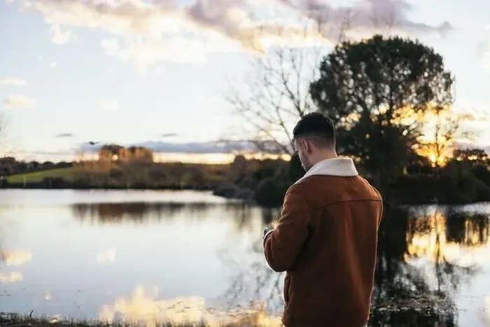 Framed Print : Young man using a drone near a lake to record and photograph the landscape Framed Print : Young man using a drone near a lake to record and photograph the landscape