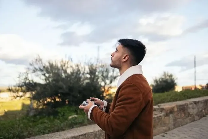 Framed Print : Young man using a drone to photograph and record the landscape Framed Print : Young man using a drone to photograph and record the landscape