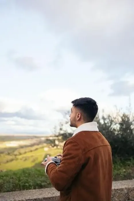 Framed Print : Young man using a drone to photograph and record the landscape Framed Print : Young man using a drone to photograph and record the landscape