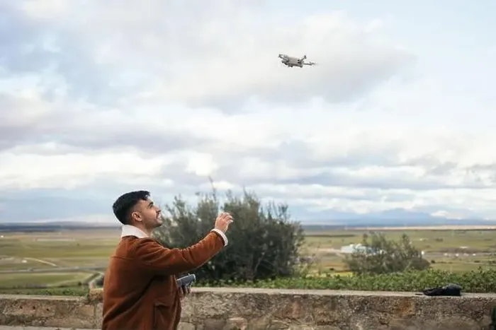 Framed Print : Young man using a drone to record and photograph the landscape Framed Print : Young man using a drone to record and photograph the landscape