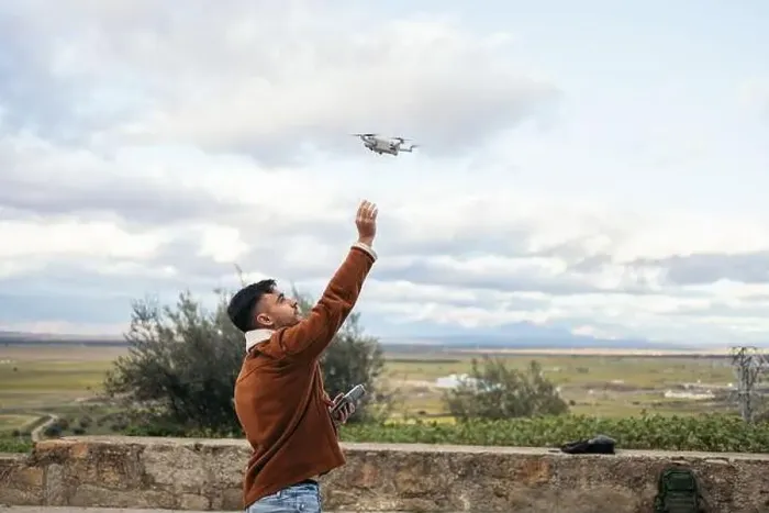 Framed Print : Young man using a drone to record and photograph the landscape Framed Print : Young man using a drone to record and photograph the landscape
