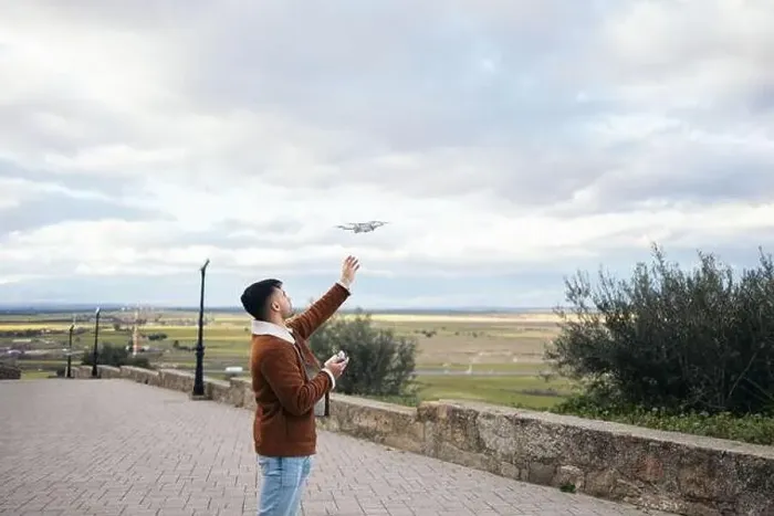 Framed Print : Young man using a drone to record and photograph the landscape Framed Print : Young man using a drone to record and photograph the landscape