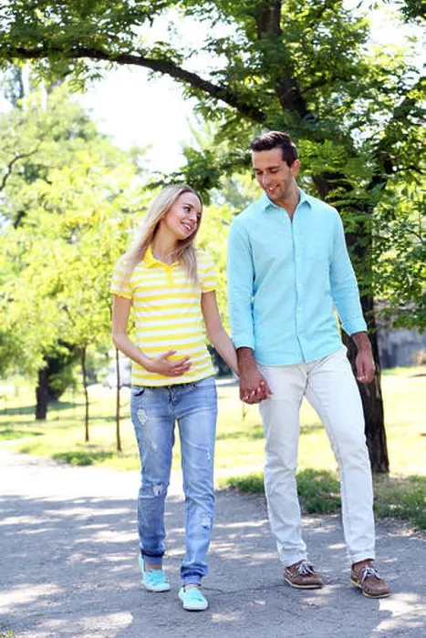 Framed Print : Young pregnant woman with husband walking in park Framed Print : Young pregnant woman with husband walking in park