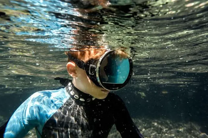Framed Print : A young snorkeler explores the vibrant underwater sea life in the crystal-clear waters off the coast of Menorca, Spain