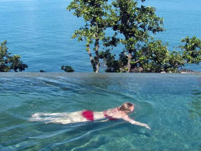 Framed Print : Young Western woman in a bikini swimming in an infinity pool at Six Senses Krabey Island, Cambodia Framed Print : Young Western woman in a bikini swimming in an infinity pool at Six Senses Krabey Island, Cambodia