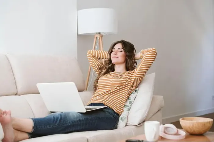 Framed Print : Young woman with laptop relaxing on sofa at home Framed Print : Young woman with laptop relaxing on sofa at home