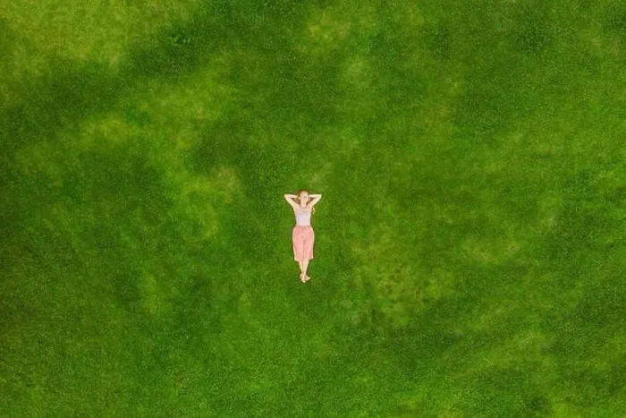 Framed Print : Young woman lying down in the middle of a field and relaxing, drone photo Framed Print : Young woman lying down in the middle of a field and relaxing, drone photo
