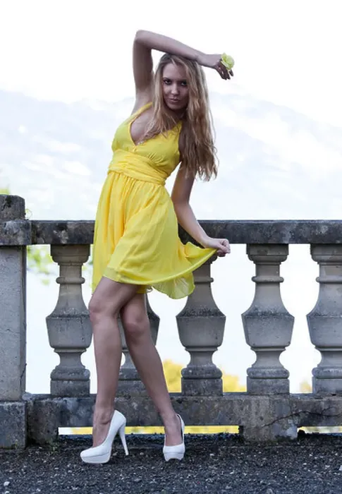 Framed Print : Young woman posing in a yellow dress with white high heels in front of a balustrade Framed Print : Young woman posing in a yellow dress with white high heels in front of a balustrade