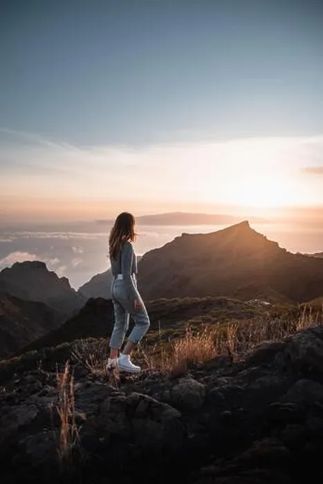 Framed Print : Young woman with urban outfit looking at a beautiful sunset from the top of Teno on the canary island of Tenerife during her tourist vacation Framed Print : Young woman with urban outfit looking at a beautiful sunset from the top of Teno on the canary island of Tenerife during her tourist vacation