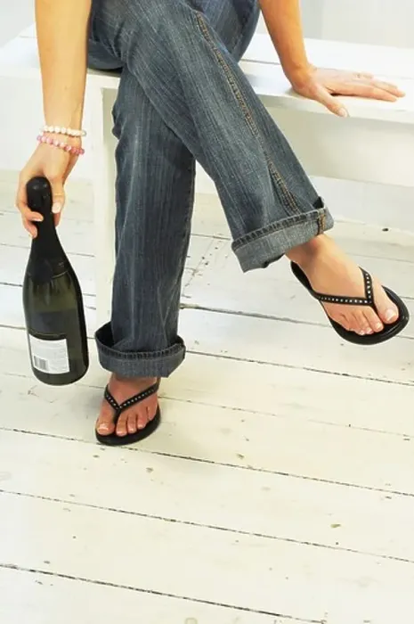 Framed Print : Young womans legs and feet with Champagne Bottle Framed Print : Young womans legs and feet with Champagne Bottle