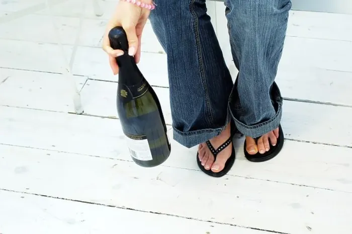 Framed Print : Young womans legs and feet with Champagne Bottle Framed Print : Young womans legs and feet with Champagne Bottle