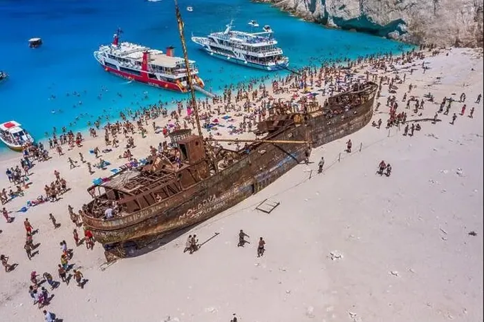 Framed Print : Zakynthos, Greece - August 20, 2019: Tourists enjoy summer time by abandoned rusty ship on shipwreck navagio beach Framed Print : Zakynthos, Greece - August 20, 2019: Tourists enjoy summer time by abandoned rusty ship on shipwreck navagio beach
