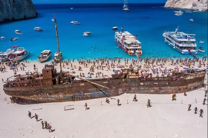 Framed Print : Zakynthos, Greece - August 20, 2019: Tourists enjoy summer time by abandoned rusty ship on shipwreck navagio beach Framed Print : Zakynthos, Greece - August 20, 2019: Tourists enjoy summer time by abandoned rusty ship on shipwreck navagio beach