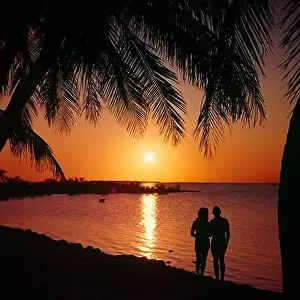 1960s ANONYMOUS SILHOUETTED COUPLE MAN AND WOMAN TOGETHER ON VACATION ON TROPICAL BEACH LOOKING AT SUNSET - kl2792 SHE002 HARS FEMALES MARRIED SPOUSE