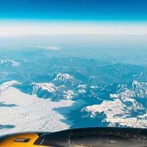 Aerial View From Airplane Window On Snowy Top Of Tatra Mountains In Summer Day. High Attitude Aerial View From Airplane Window On Snowy Top Of Tatra Mountains In Summer Day. High Attitude