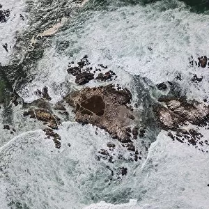 The cold waters of the Pacific Ocean wash against the rocky Northern California coastline in Monterey, just south of San Francisco