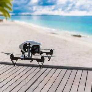 Flying drone with mounted camera at the beach. Palm trees and blue lagoon Flying drone with mounted camera at the beach. Palm trees and blue lagoon