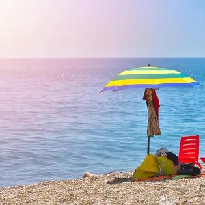 Pair of sun loungers and a beach umbrella on a deserted beach; perfect vacation concept Pair of sun loungers and a beach umbrella on a deserted beach; perfect vacation concept