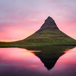 Picturesque panoramical landscape with Kirkjufell mountain, clear lake and cloudscape in sunset sky