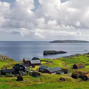 Summer view of small village with typical faroese turf-top houses on outskirts of Torshavn city, capital of Faroe Islands, Streymoy island, Denmark