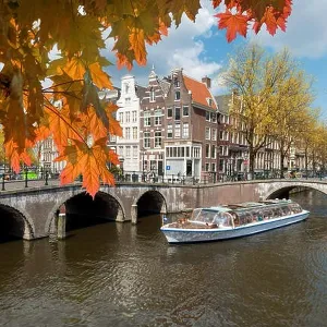 Traditional old houses on canal at fall day in Amsterdam, Netherlands at autumn season Traditional old houses on canal at fall day in Amsterdam, Netherlands at autumn season
