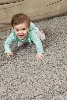 Crawl Prints: 10 month old baby girl crawling on rug at home
