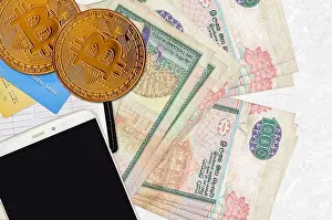 Transaction Prints: 1000 Sri Lankan rupees bills and golden bitcoins with smartphone and credit cards