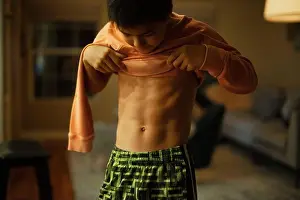 Tween Prints: A 12-year old boy flexes his abdomen muscles