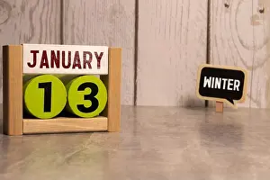 Monthly Prints: 13 Januar on wooden grey cubes. Calendar cube date 13 January. Concept of date