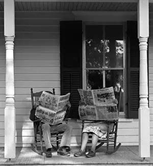 Grown Up Prints: 1950s 1960s COUPLE MAN WOMAN SITTING ON PORCH IN ROCKING CHAIRS HOLDING NEWSPAPERS UP HIDING THEIR FACES