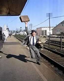Briefcase Prints: 1950s DISTRESSED MAN LATE BUSINESSMAN WITH BRIEFCASE IN AIR RUNNING CALLING YELLING AFTER DEPARTING COMMUTER TRAIN