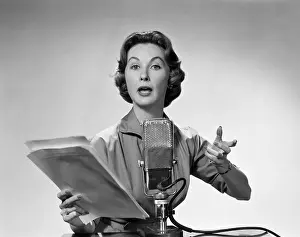 Hars Prints: 1950s WOMAN TALKING INTO MICROPHONE HOLDING PAPERS WITH EXAGGERATED EXPRESSION