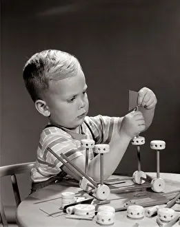Toys Prints: 1960s BOY SEATED AT TABLE PLAYING WITH TINKER TOY CONSTRUCTION SET