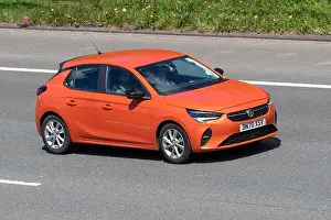 Road Travel Prints: 2020 NEW ALL-ELECTRIC CORSA-E; orange Vauxhall Corsa Se Nav 1199cc hatchback; driving on the M61 motorway UK