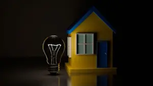 Apartment Prints: 3D model of an incandescent light bulb and a house in the colors of the Ukrainian flag on a mirror dark background
