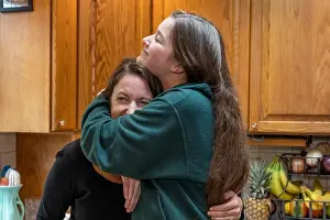 Fondness Prints: 42 year old mother and her 15 year old daughter playfully hugging