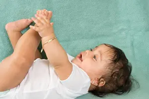 Latina Prints: 6 month old baby girl on back close up reaching for foot