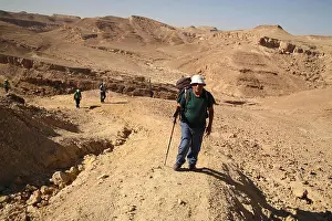 Citizens Prints: A 79 year old senior citizen man hiker is leading other hikers walking up above Nachal or Nahal Marzeva in the Negev