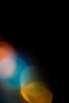 Bokeh Prints: Abstract colorful light glowing and blurring on a dark background creating a unique texture or overlay
