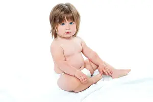 Diaper Prints: Adorable baby girl sitting up wearing a diaper. Looking at camera