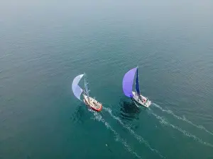 Sapphire Prints: Aerial bird's eye view photo taken by drone of sailboat in turquoise sea water