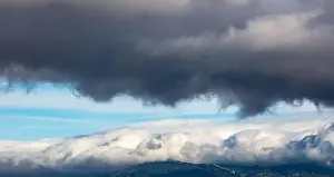 Aerial, drone, dark grey and white clouds on blue sky background
