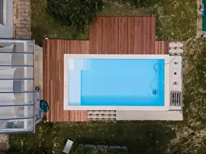 Laziness Prints: aerial drone flight over beautiful green garden with pool and the wooden deck of the pool is in progress